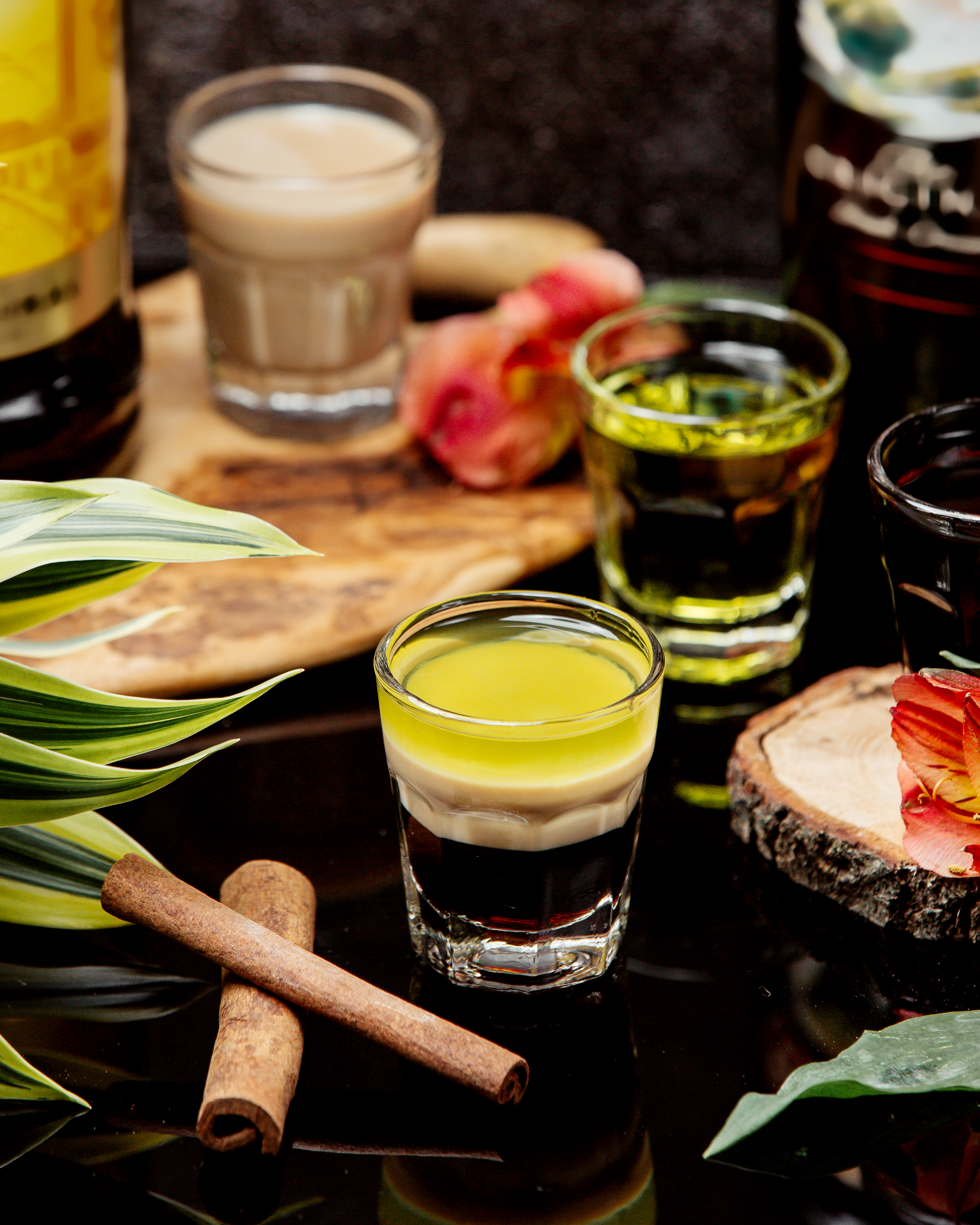 Mesa com vários copos de shot cheios de bebidas típicas.