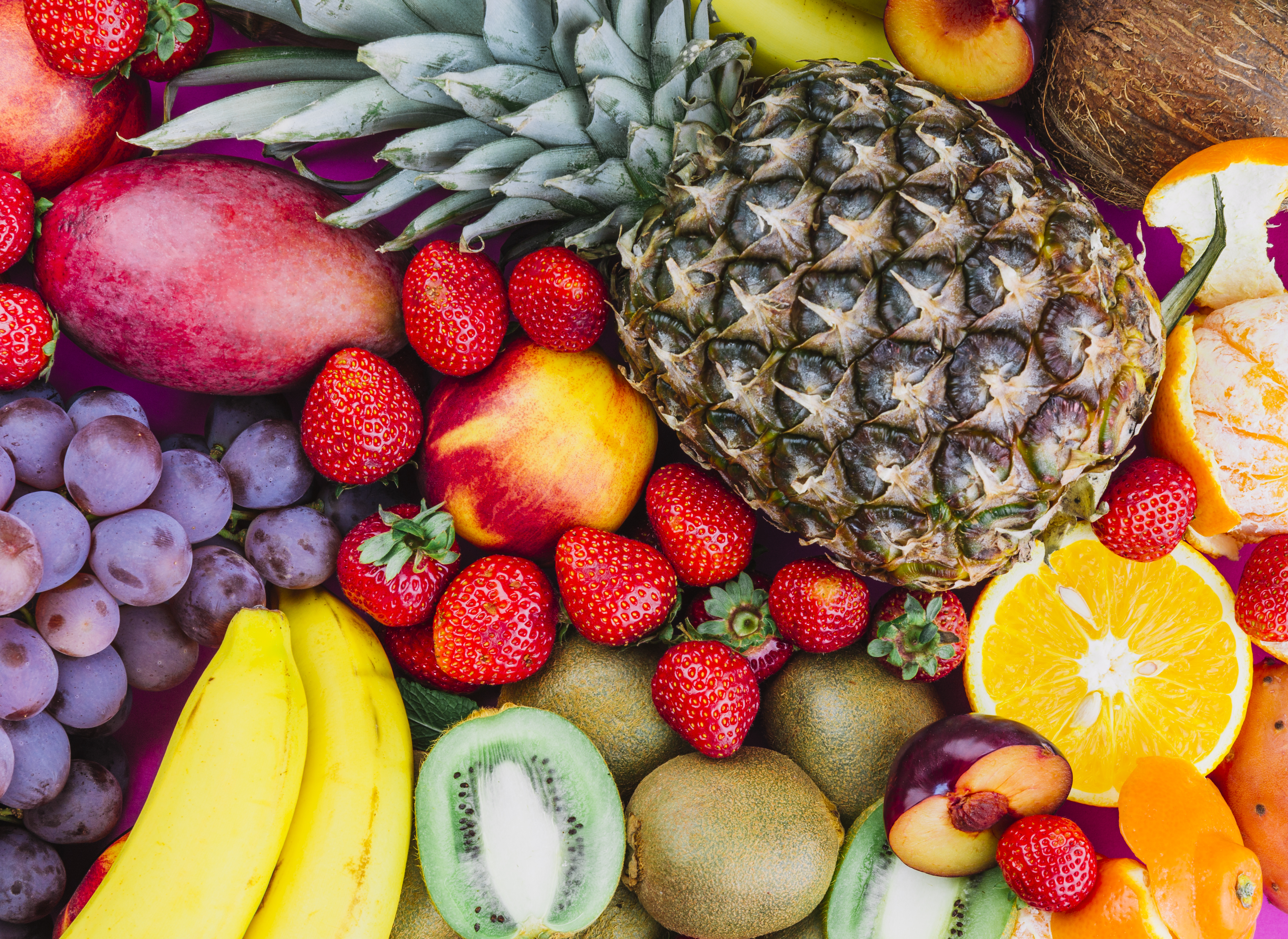 Várias frutas sobrepostas, abacaxi, banna, morango, manga, entre outras. 